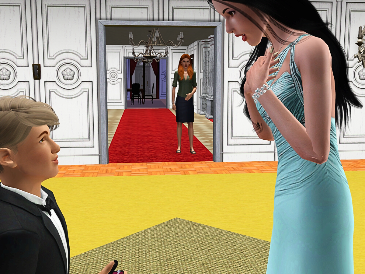 A young boy in a tuxedo is proposing to a woman in a blue dress, while a woman in a black dress stands in the background observing the moment.