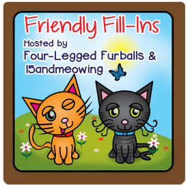 A colorful graphic featuring two cartoon cats, one orange and one black, on a grassy hill with flowers and a blue sky. The text reads 'Friendly Fill-Ins' and mentions 'Hosted by Four-Legged Furballs & 15andmeowing'.