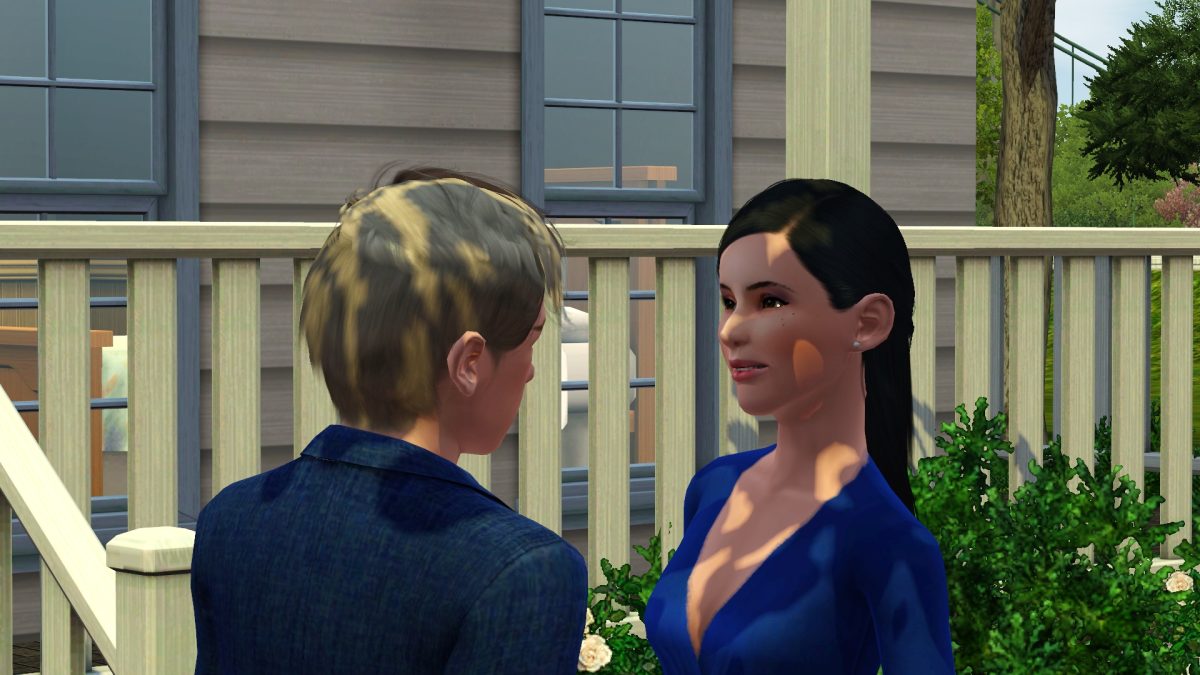 A young man and woman are smiling and engaging in conversation in front of a house. The woman is wearing a blue blouse, and there are plants in the foreground.